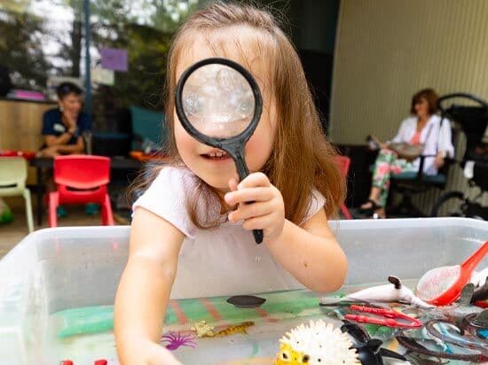 Child Playing with Magnifying Glass