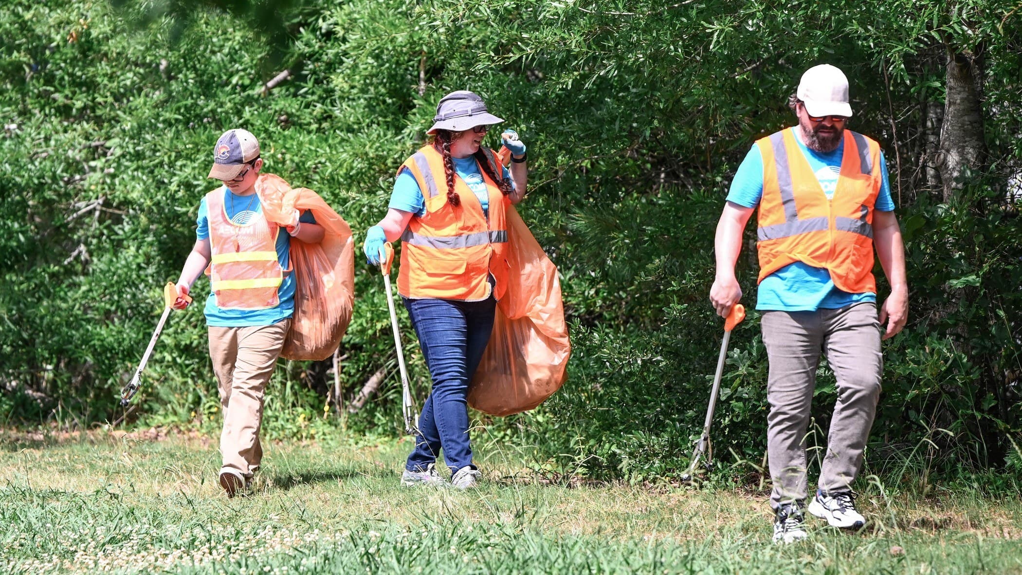 Creek Cleanup volunteers in high vis vests search for trash