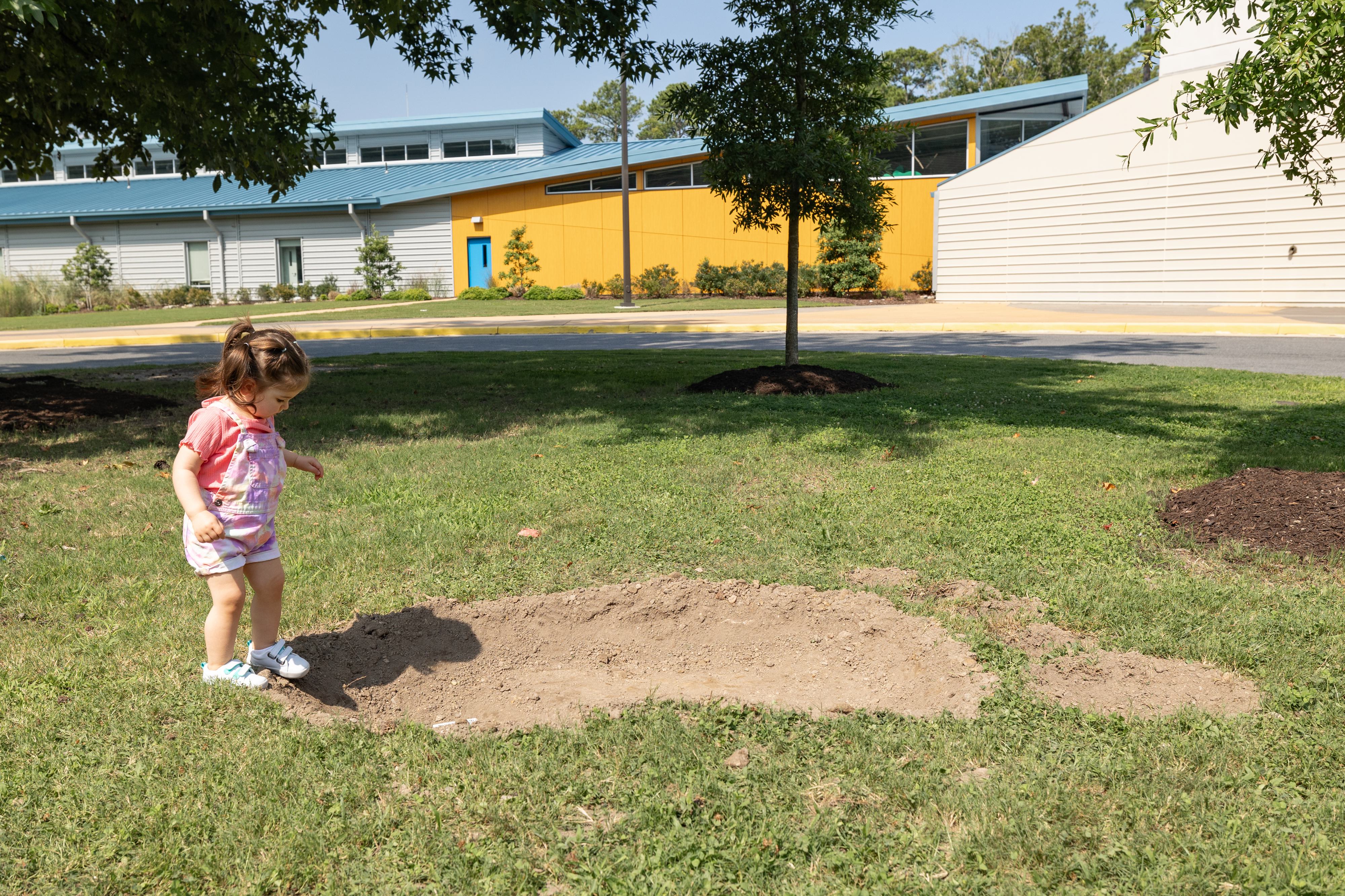 Toddler standing in a large footprint in front of the Aquarium